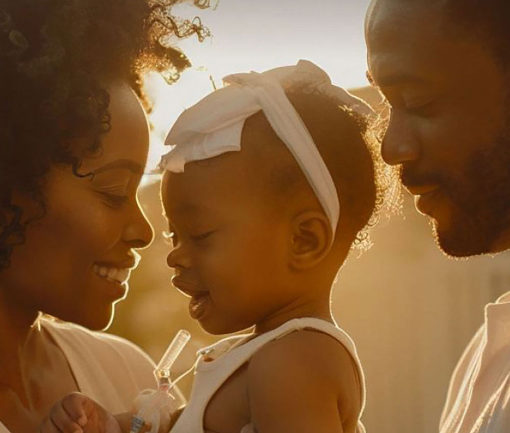 Mom and dad withe little girl with bow